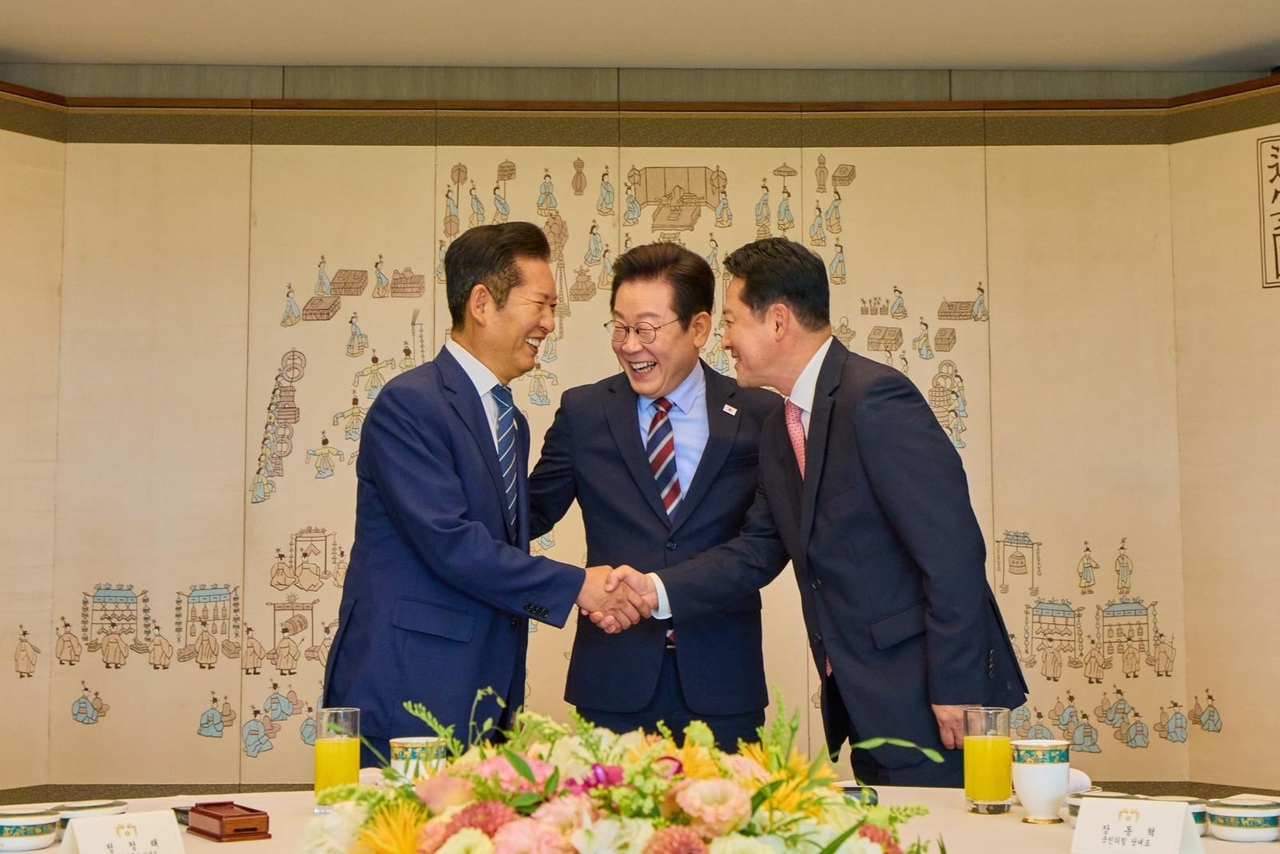 President Lee Jae Myung (center) greets Rep. Jung Chung-rae (left), leader of the ruling Democratic Party, and Rep. Jang Dong-hyeok, leader of the main opposition People Power Party, during their luncheon at the presidential office in Seoul on Sept. 8, 2025. (Office of the President)