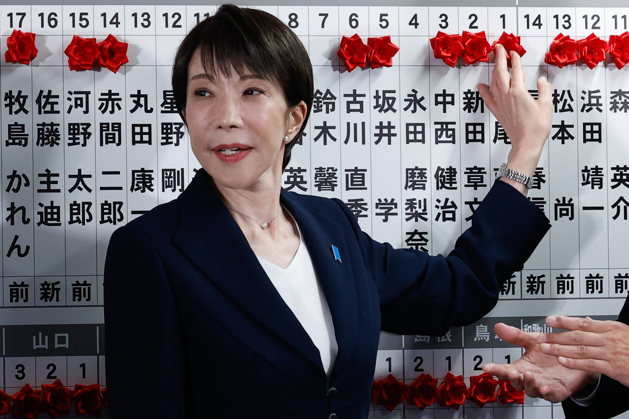 Sanae Takaichi, Japan's prime minister and president of the ruling Liberal Democratic Party, places pins next to the names of candidates who won lower house elections at the LDP headquarters on Feb. 8 in Tokyo. (AP-Yonhap)