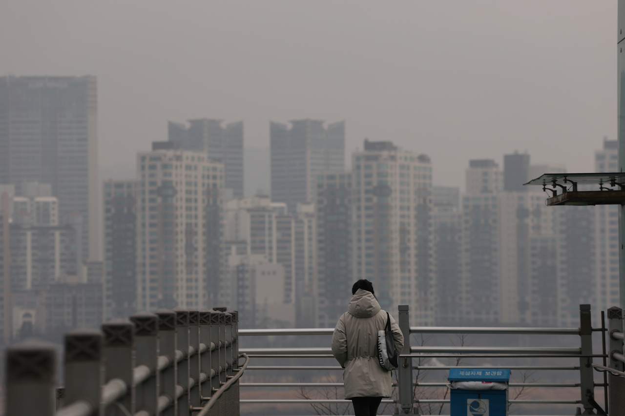 A pedestrian walks in Seoul on Feb. 5 as ultrafine dust levels are recorded at “bad.” (Yonhap)