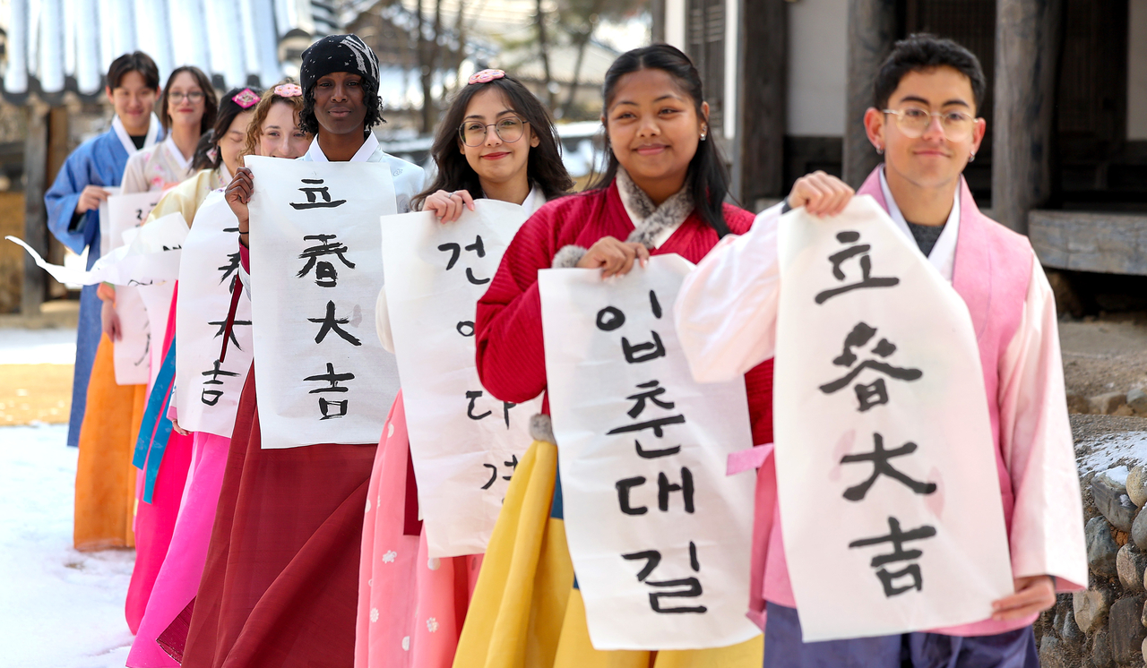 This photo shows foreign students in Yeungnam University holding traditional decorations used in doorsteps during spring season on Feb. 2. (Newsis)
