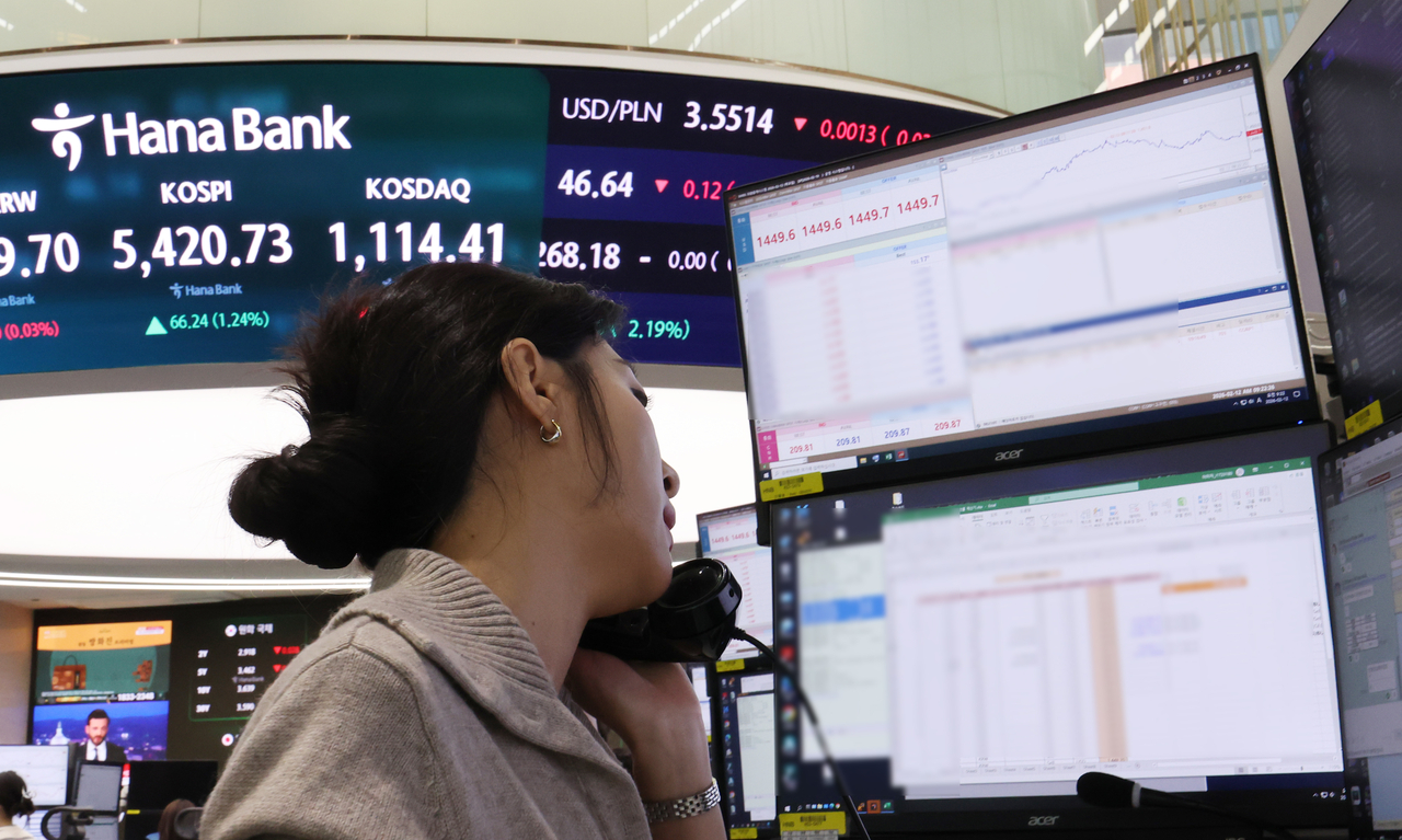 A trader takes a phone call at Hana Bank’s dealing room at its headquarters in central Seoul, Thursday. (Yonhap)