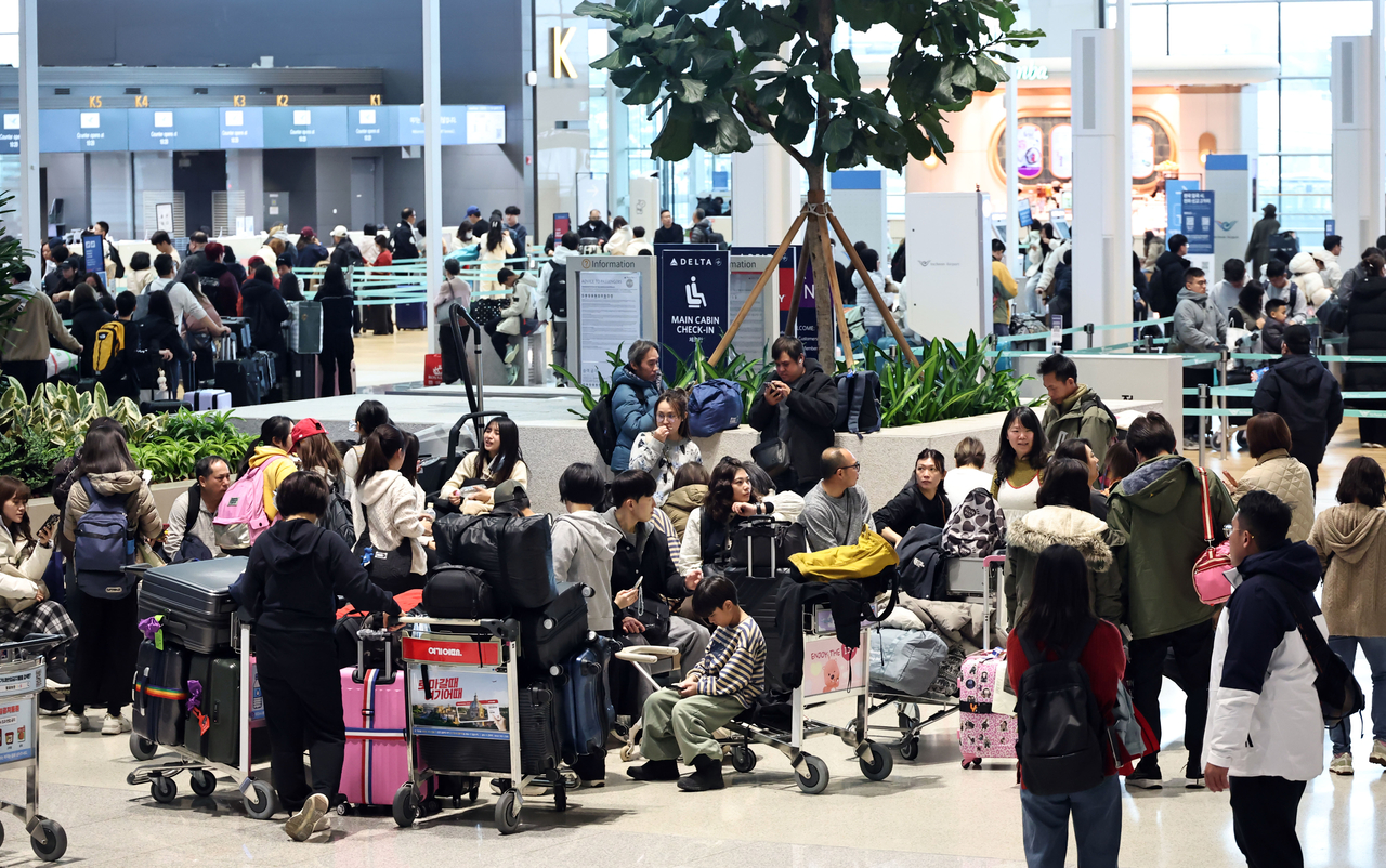 Ahead of the Lunar New Year holiday, passengers line up at the departure hall of Terminal 2 at Incheon International Airport for check-in on Friday. (Yonhap)