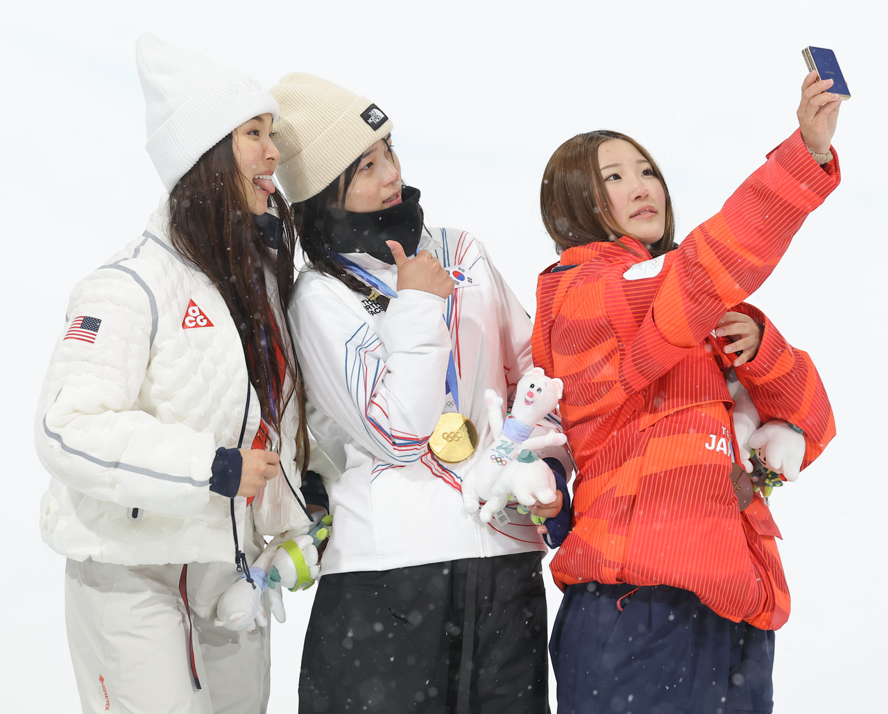 Choi Gaon (center), who won the gold medal in the women’s snowboard halfpipe final at the 2026 Milan-Cortina Winter Olympics, poses for a photo with silver medalist Chloe Kim of the US (left) and bronze medalist Mitsuki Ono of Japan. (Yonhap)
