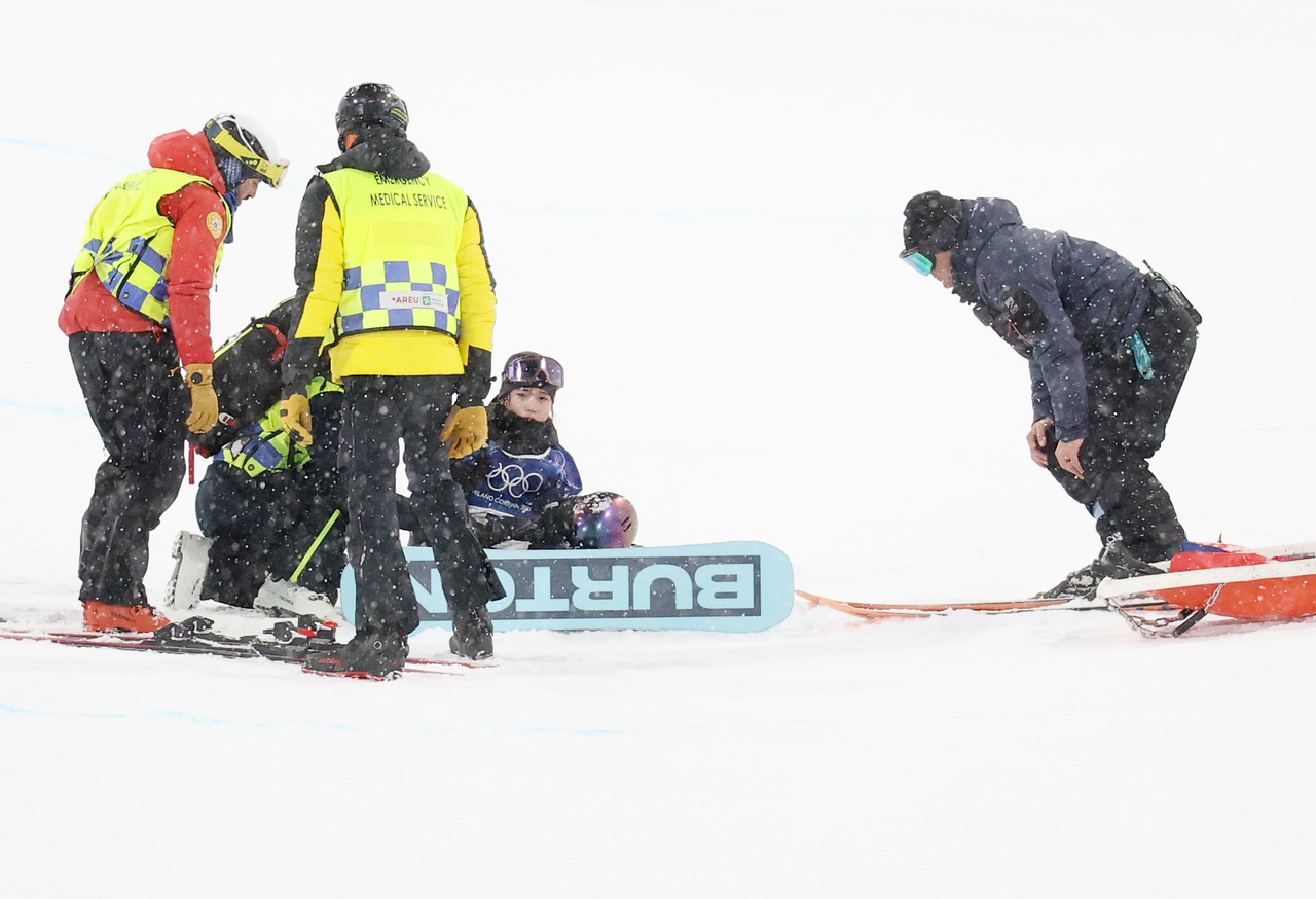 Choi is examined by medical staff after a heavy fall during her first run. (Yonhap)