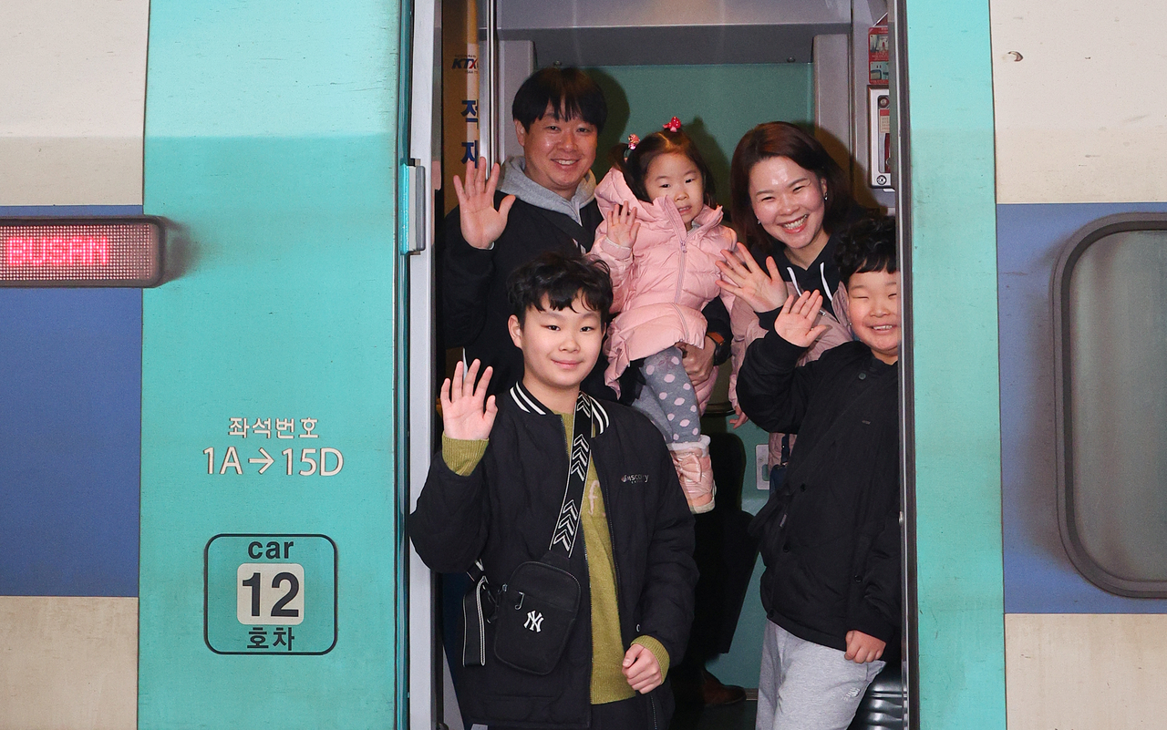 A family waves as they board a KTX train bound at Seoul Station on Friday. (Yonhap)