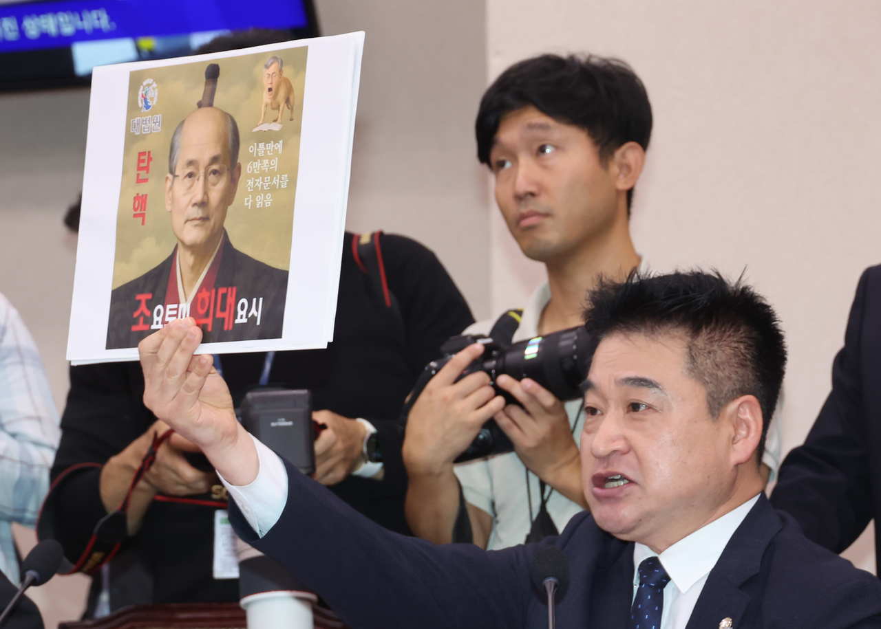 Independent Rep. Choi Hyuck-jin holds up a panel that shows a photoshopped image of Chief Justice Jo Hee-de that superimposed the face of Toyotomi Hideyoshi, the Japanese warlord that led Japan's invasion of South Korea in late 16th century, during a parliamentary audit in October. (Newsis)