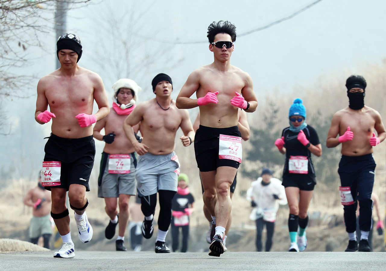 Participants run shirtless on Saturday during the Pyeongchang Daegwallyeong Naked Marathon, held in Pyeonchang, Gangwon Province. (Newsis)