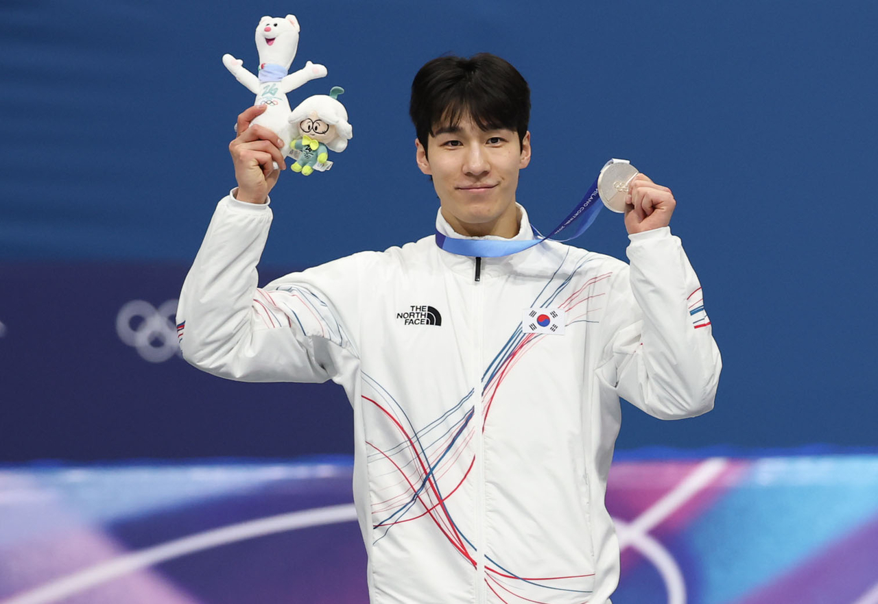 Short track speed skater Hwang Dae-heon holds up his silver medal after he finished second in the men's 1,500 meters at the Milan-Cortina Winter Olympics on Saturday. (Yonhap)