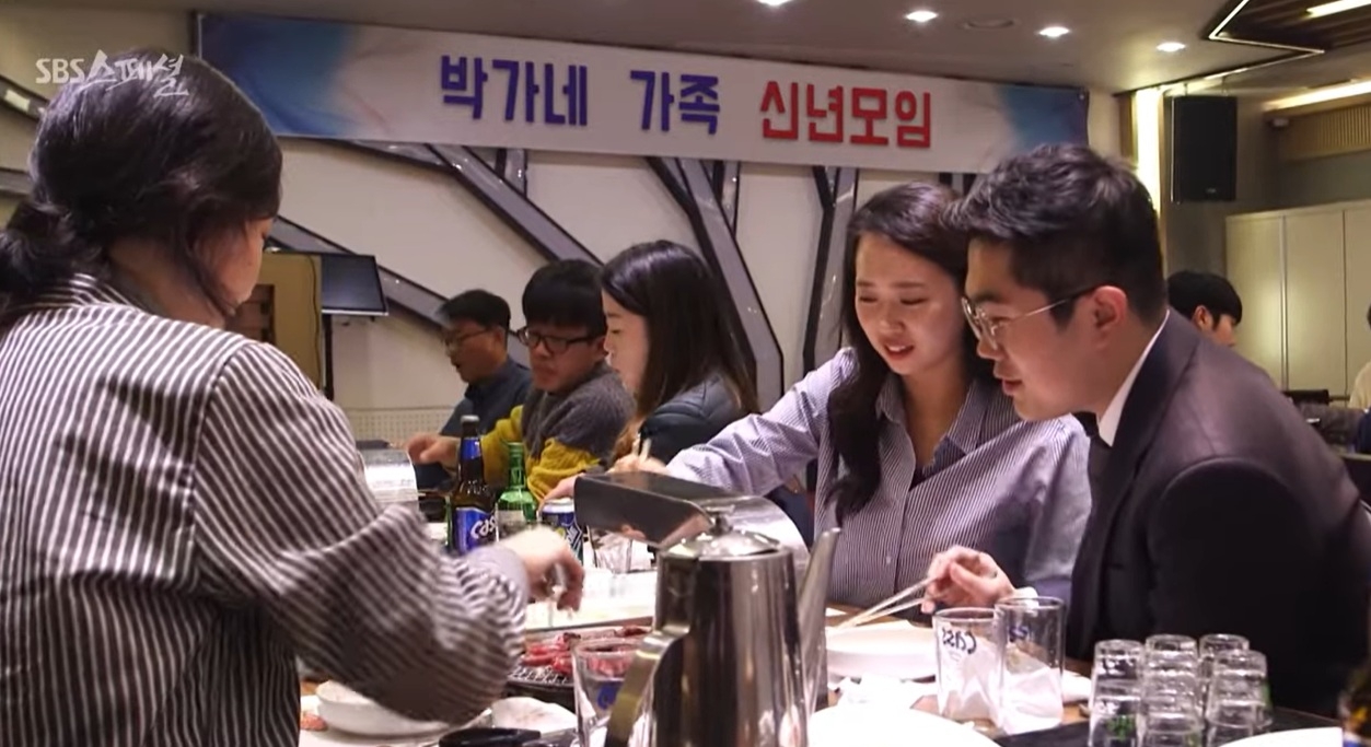 A scene from a documentary aired on SBS in 2021 that explored young married couples and their relationships with their in-laws shows a young woman taking part in a gathering with her husband’s family. (SBS)