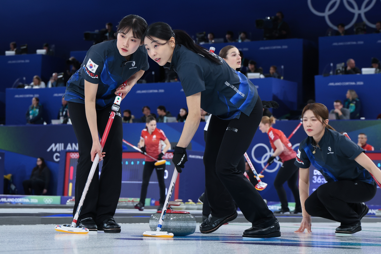 Seol Ye-eun (left) and Kim Min-ji of South Korea sweep the ice during a round-robin match against Switzerland in the women's curling tournament at the Winter Olympics at the Winter Olympics at Cortina Curling Olympic Stadium in Cortina d'Ampezzo, Italy, on Tuesday. (Yonhap)