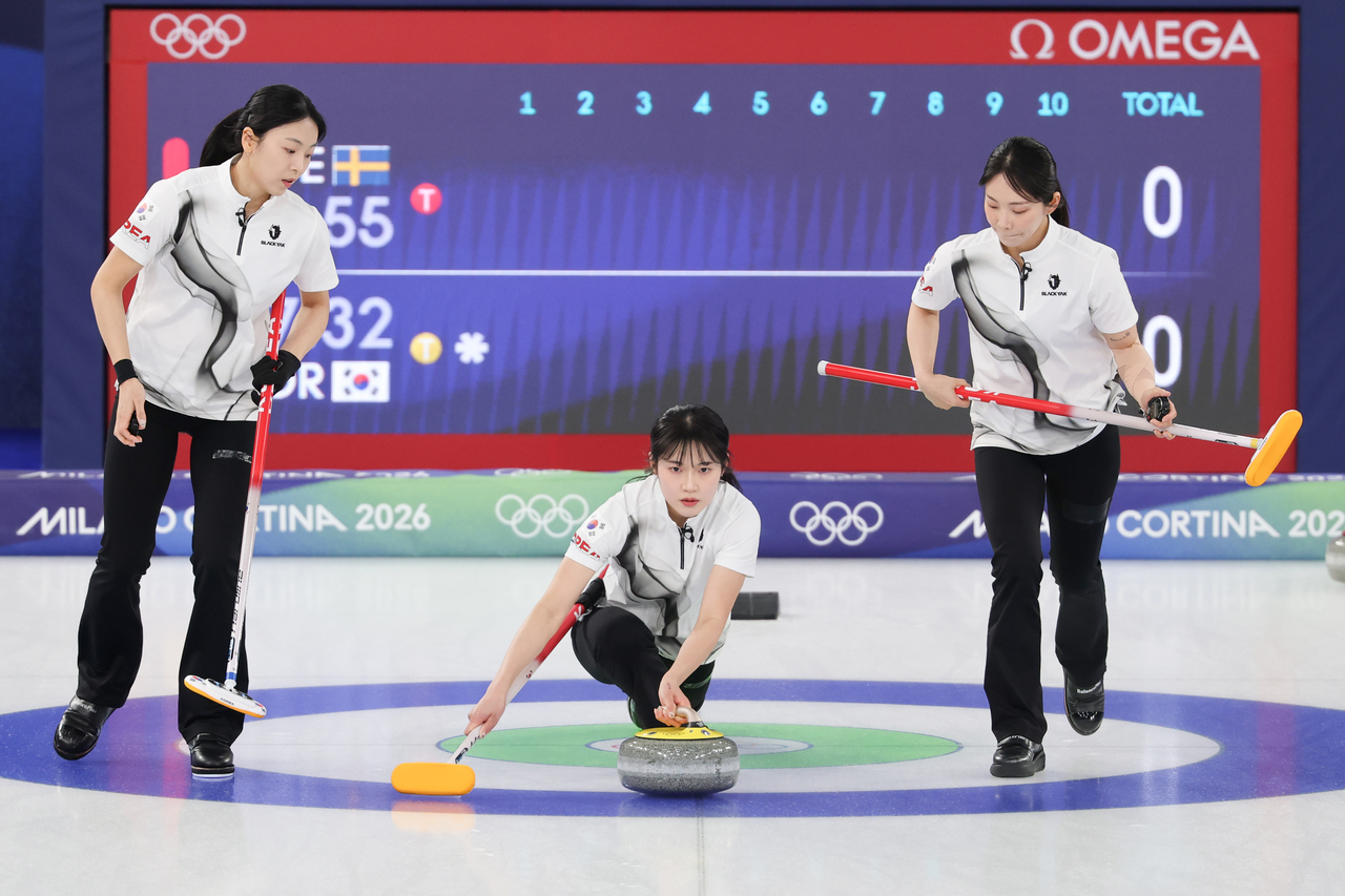 Seol Ye-eun of South Korea (center) delivers a stone between teammates Kim Min-ji (left) and Kim Su-ji during the team's round-robin match against Sweden in the women's curling tournament at the Winter Olympics at Cortina Curling Olympic Stadium in Cortina d'Ampezzo, Italy, on Wednesday. (Yonhap)
