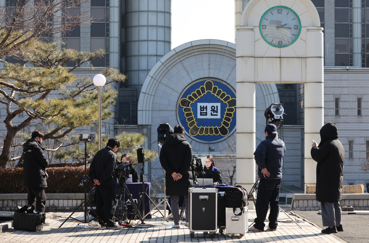 TV cameras and journalists set up for broadcasts outside the west gate of the Seoul Central District Court in Seocho-gu, Seoul, on Wednesday, a day ahead of the verdict in the case against former President Yoon Suk Yeol on charges of leading an insurrection related to his martial law declaration on Dec. 3, 2024.  (Yonhap)