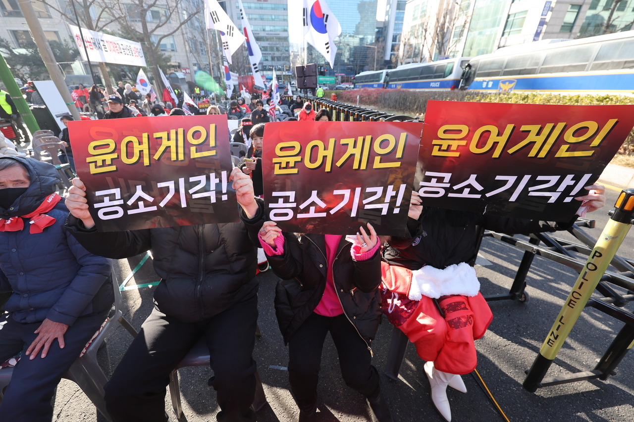 Supporters of Yoon hold banners reading “Yoon Again, Dismiss the Indictment” during a rally near the Seoul Central District Court on Thursday calling for the former president’s acquittal. (Yonhap)