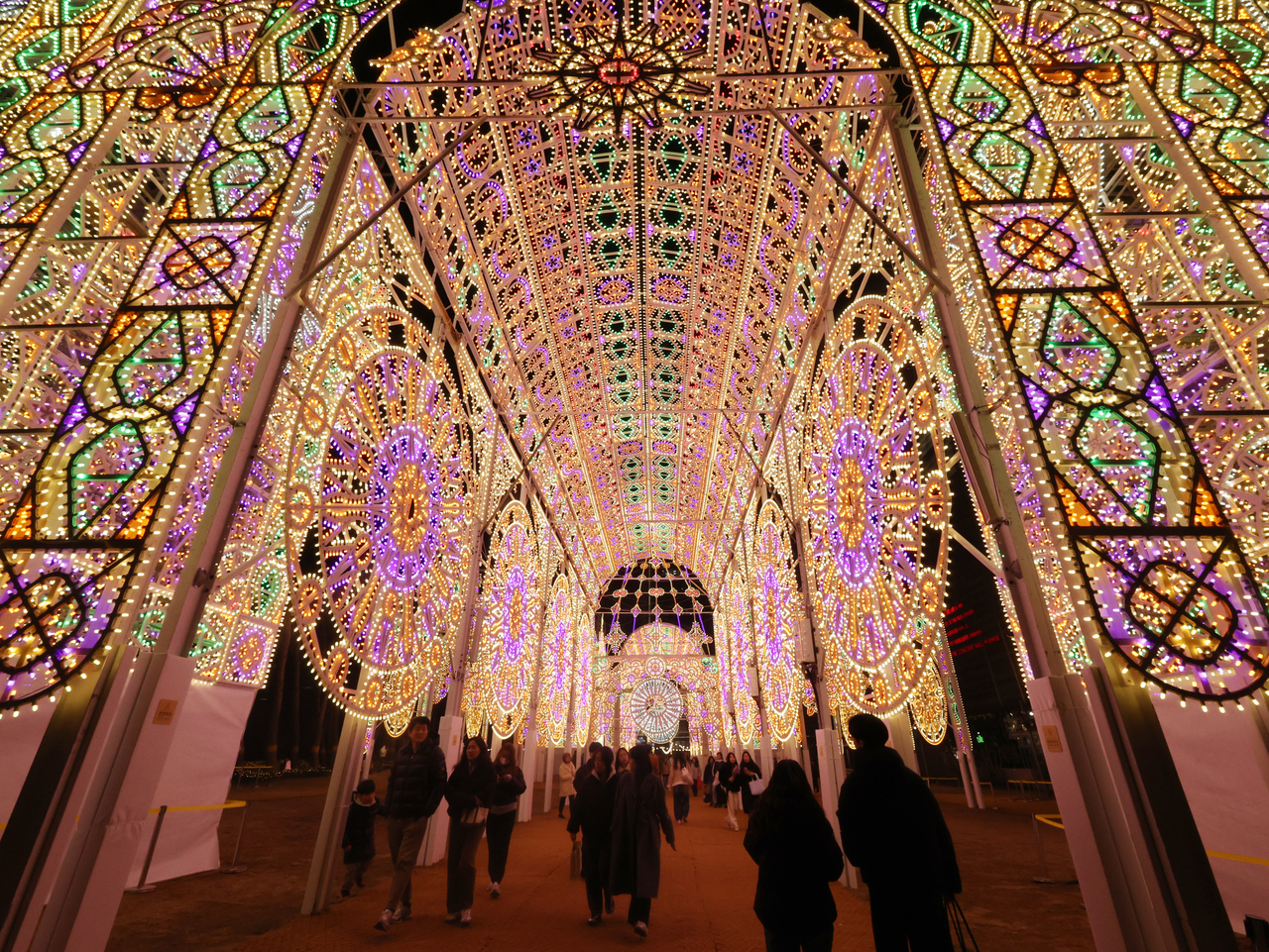 Visitors walk through the illuminated tunnel at the 2026 Lotte Luminarie at Lotte World Tower in Songpa-gu, Seoul, on Feb. 11. (Yonhap)