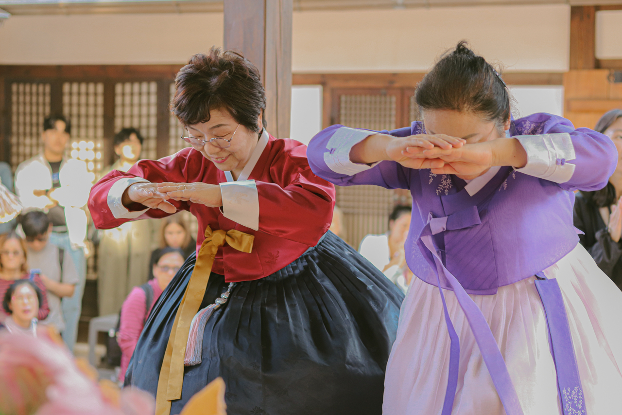 Two women demonstrate the traditional way of bowing during the Bukchon Dorak program. (Seoul Metropolitan Government)