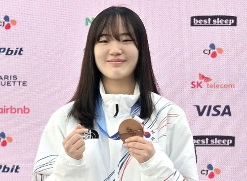 South Korean snowboarder Yu Seung-eun, the bronze medalist in the women's big air event at the Milan-Cortina Winter Olympics, poses with her medal during a press conference at Korea House in Milan on Friday. (Yonhap)