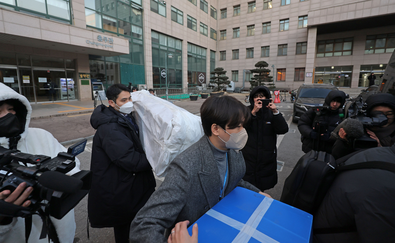 Investigators carry items seized from a raid on a university in Seoul attended by a graduate student allegedly behind recent drone flights to North Korea on Jan. 21. (Yonhap)