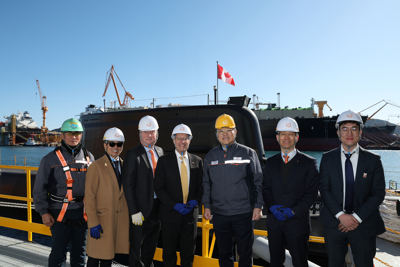 Ontario’s Minister of Economic Development poses for a commemorative photo with Hanwha Ocean CEO Kim Hee-cheol in front of the submarine Jang Young-sil, built by Hanwha Ocean, during a visit to the company’s Geoje shipyard on Jan. 22. (Hanwha Ocean)