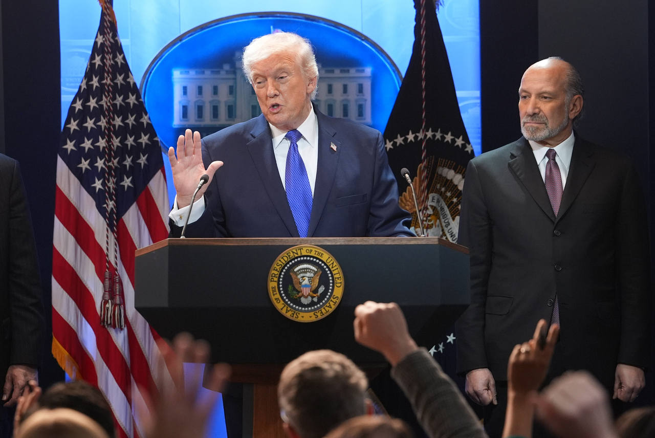 President Donald Trump speaks during a press briefing at the White House, Friday in Washington, as Commerce Secretary Howard Lutnik, looks on. (AP-Yonhap)