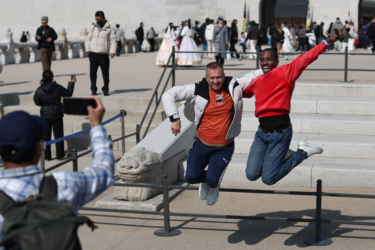 Tourists take picture in central Seoul on Saturday. (Yonhap)