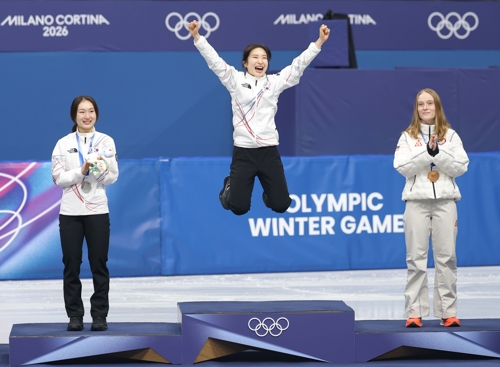 Kim Gil-li of South Korea (C) jumps onto the podium after winning the gold medal in the women's 1,500-meter short track speed skating event at the Winter Olympics at Milano Ice Skating Arena in Milan on Friday. Kim is flanked Choi Min-jeong of South Korea (L), the silver medalist, and Corinne Stoddard of the United States, the bronze medal winner. (Yonhap)
