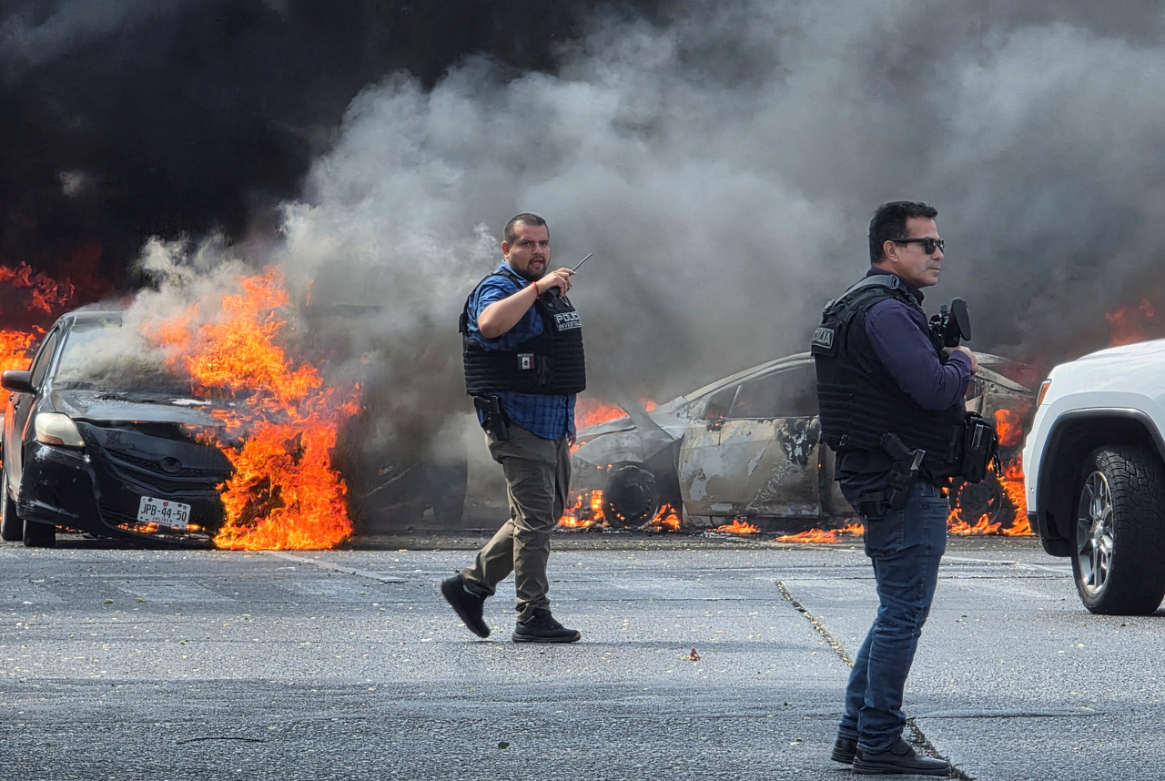 Police officers secure the area where vehicles were set on fire in Zapopan, Mexico, Sunday. (Reuters-Yonhap)