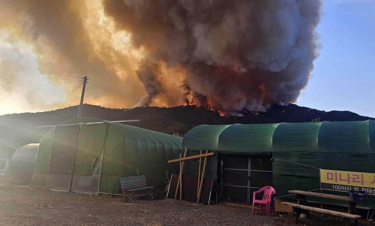 Smoke rises from a wildfire that broke out on a hill in Geomse-ri, Samnangjin-eup, Miryang, South Gyeongsang Province, at about 4:10 p.m. on Monday. (Yonhap)