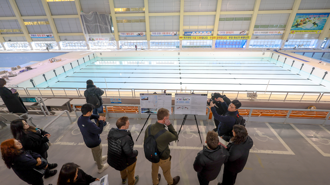 Moon Hyun-kyu (center), director of rehabilitation sports at the Korea Disabled Veterans Association, briefs Invictus Games Foundation delegation members at Yongun International Swimming Pool in Daejeon on Wednesday. (Ministry of Patriots and Veterans Affairs)