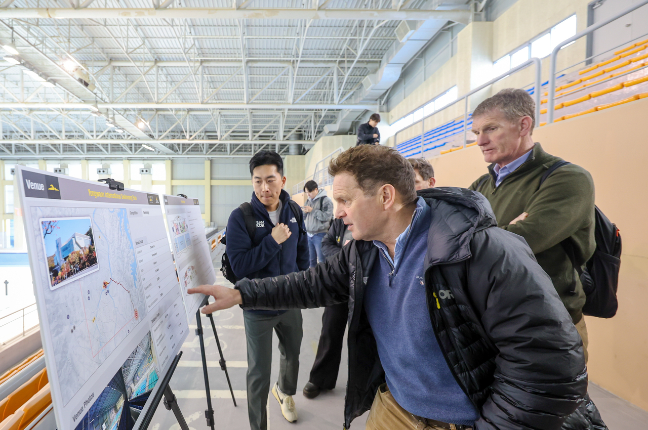 Rob Owen (front), chief executive of the Invictus Games Foundation, looks over presentation materials alongside Moon Hyun-kyu (left), director of rehabilitation sports at the Korea Disabled Veterans Association, and Richard Smith (right), deputy chief executive of the foundation, at Yongun International Swimming Pool in Daejeon on Wednesday. (Ministry of Patriots and Veterans Affairs)