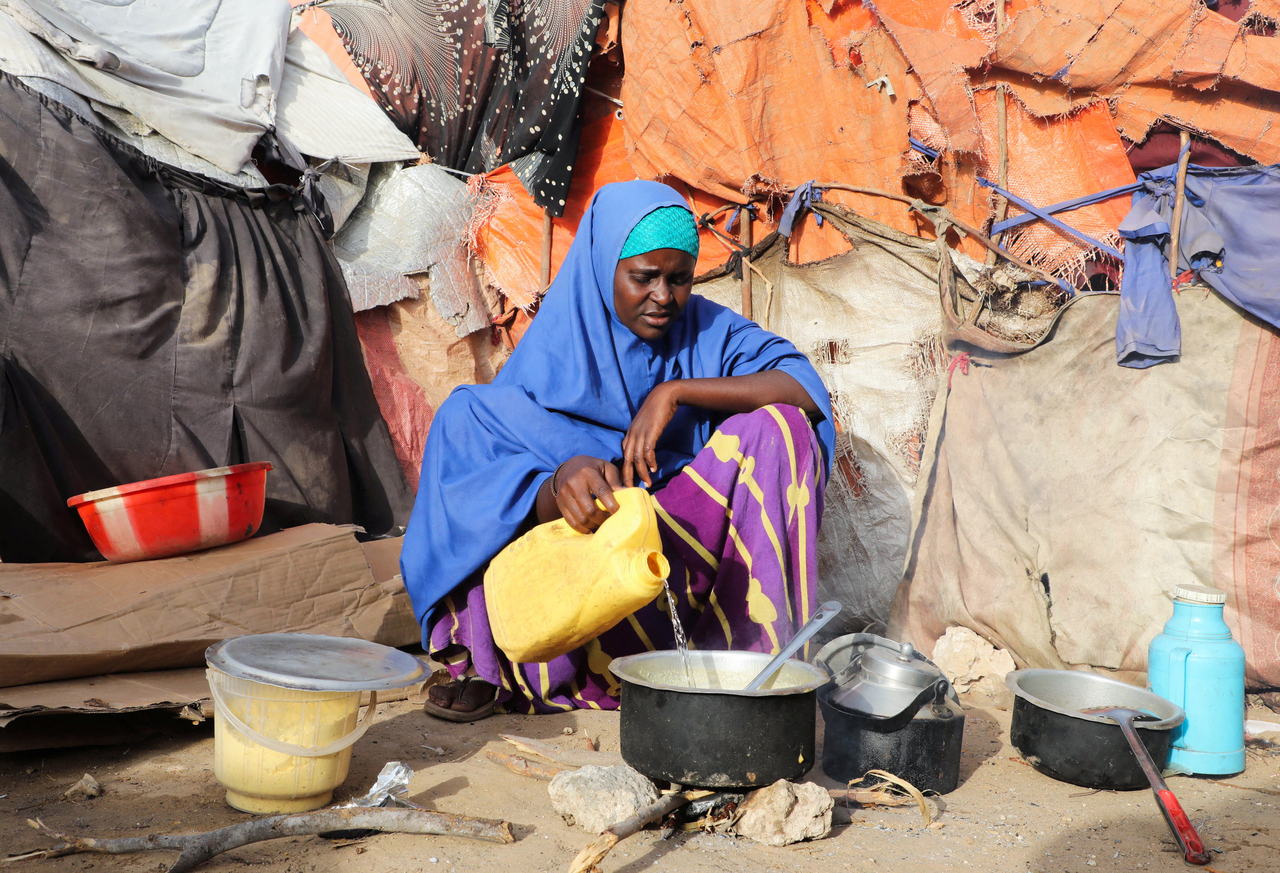 A person prepares a meal outside a shelter in Mogadishu, Somalia, Friday. (Reuters-Yonhap)