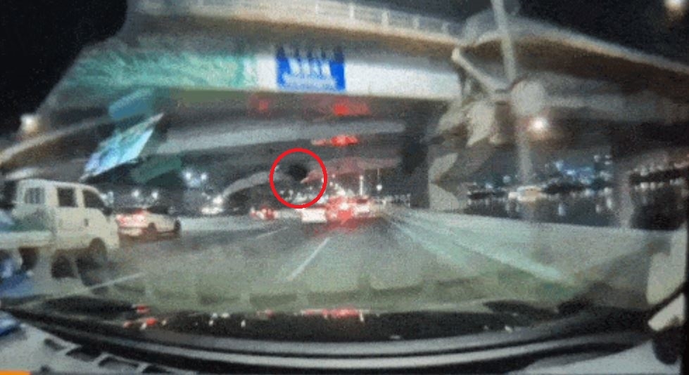 This screengrab from dashcam footage, provided to Yonhap News Agency by a reader, shows a vehicle falling onto another car after dropping off the Banpo Bridge in Seoul on Wednesday. (Yonhap)