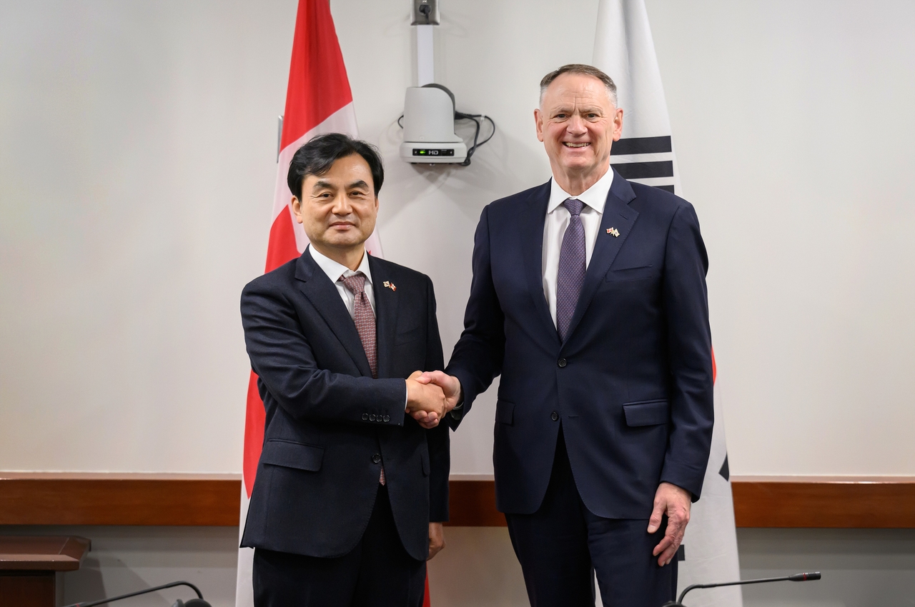 South Korean Defense Minister Ahn Gyu-back and his Canadian counterpart, David McGuinty, shake hands during their meeting in Ottawa on Wednesday. (Defense ministry)