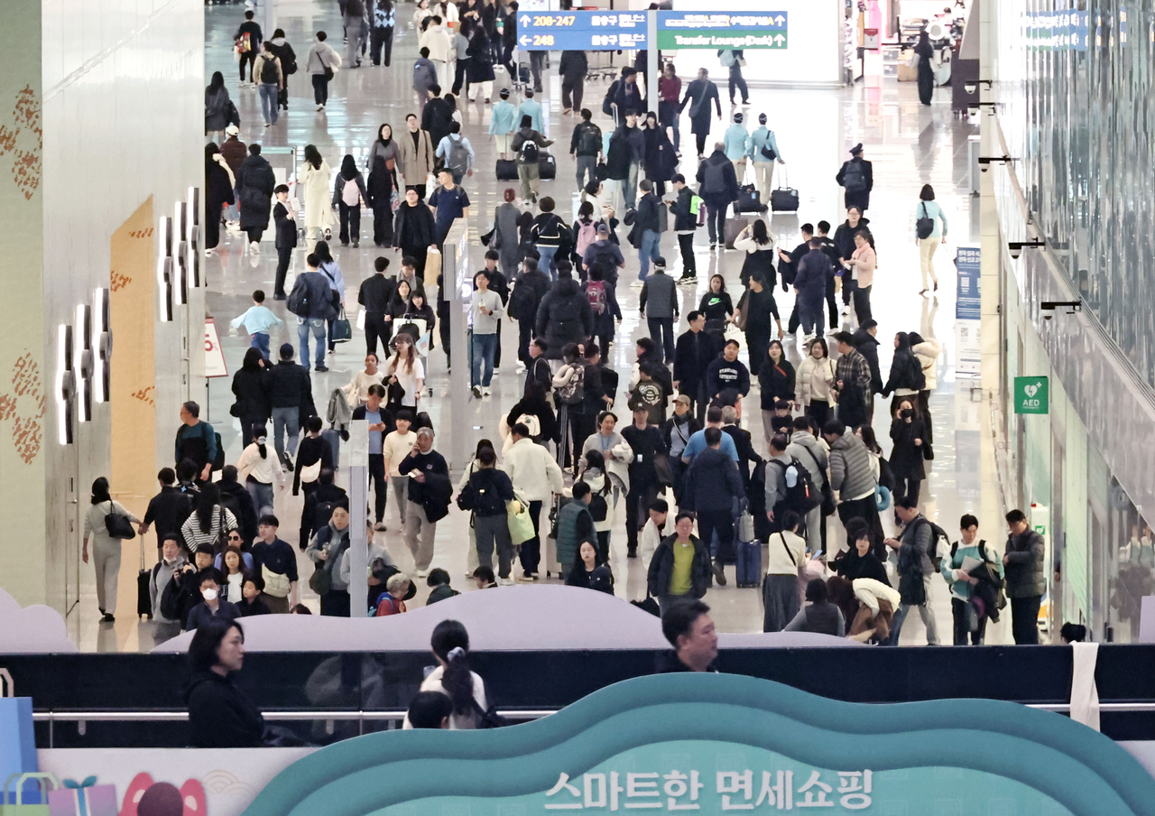 This file photo, taken Feb. 13, shows outbound travelers at a duty-free area in Terminal 2 of Incheon International Airport in Incheon, just west of Seoul, ahead of the Lunar New Year holiday. (Yonhap)