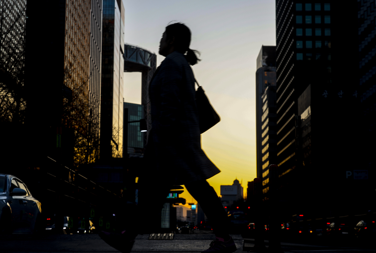 A passerby crosses the street in Gwanghwamun, central Seoul, Feb. 19.  (Newsis)