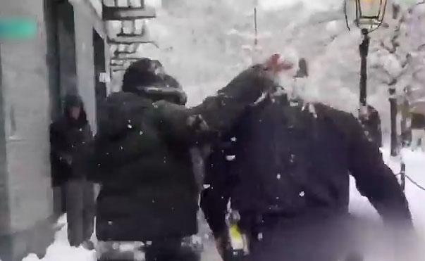 지난 23일(현지시간) 미국 뉴욕 맨해튼에서 열린 눈싸움 행사에서 경찰관에 눈덩이를 던지고 있는 시민. [KBS 보도화면 캡처]