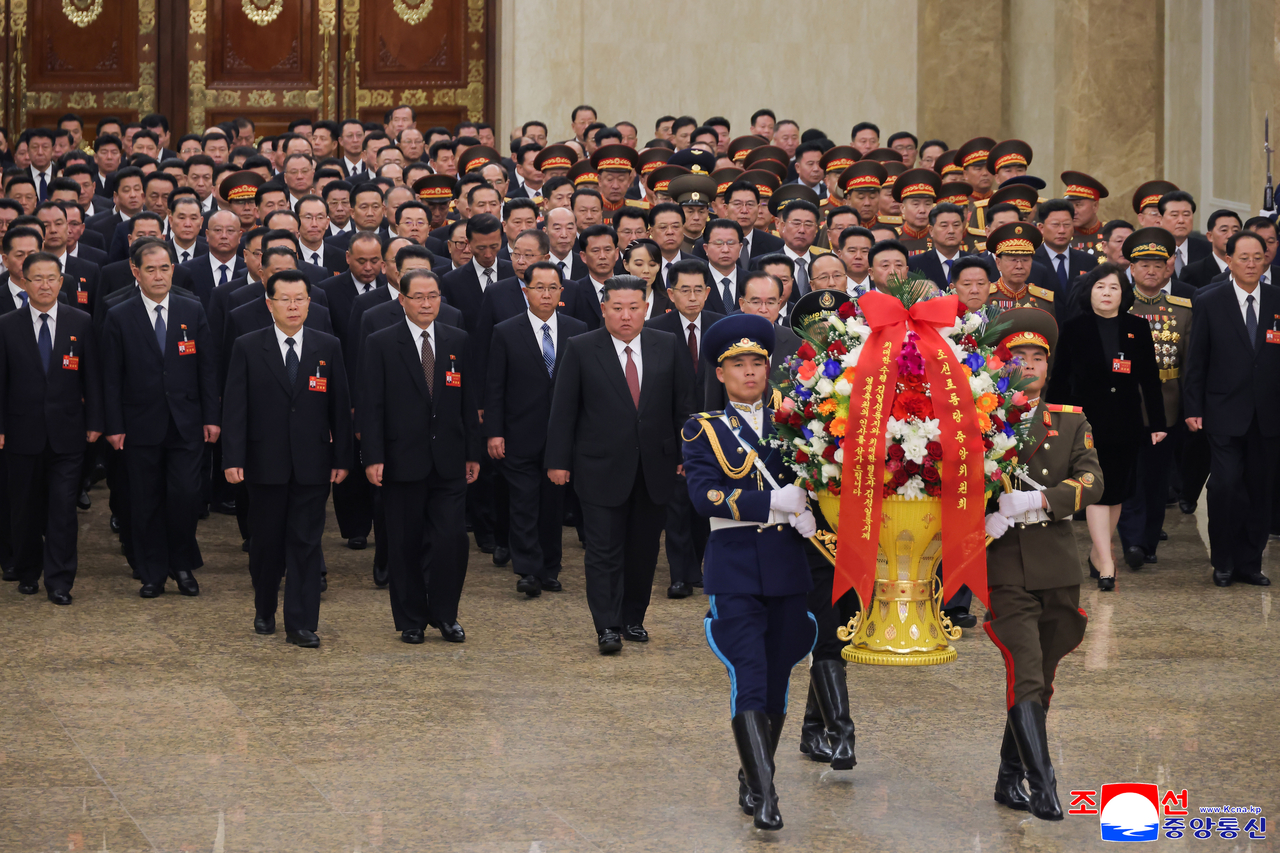 North Korea's leader Kim Jong-un (center) and newly elected members of the central leadership of the ruling Workers' Party of Korea visit the Kumsusan Palace of the Sun on Friday, after the country wrapped up its ninth party congress. (KNCA via Yonahp)