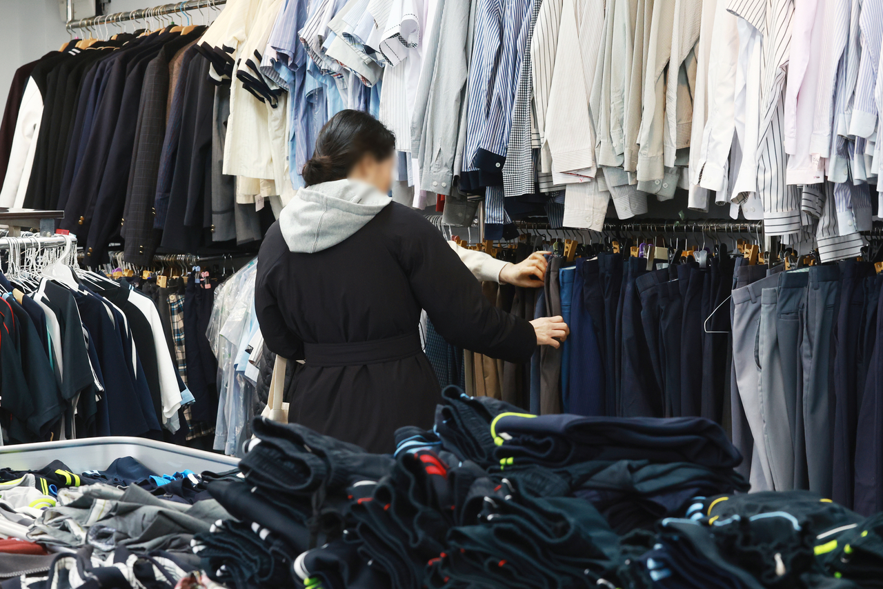Parents shop for school uniforms at a uniform-sharing store in Songpa-gu, Seoul, Thursday. (Yonhap)