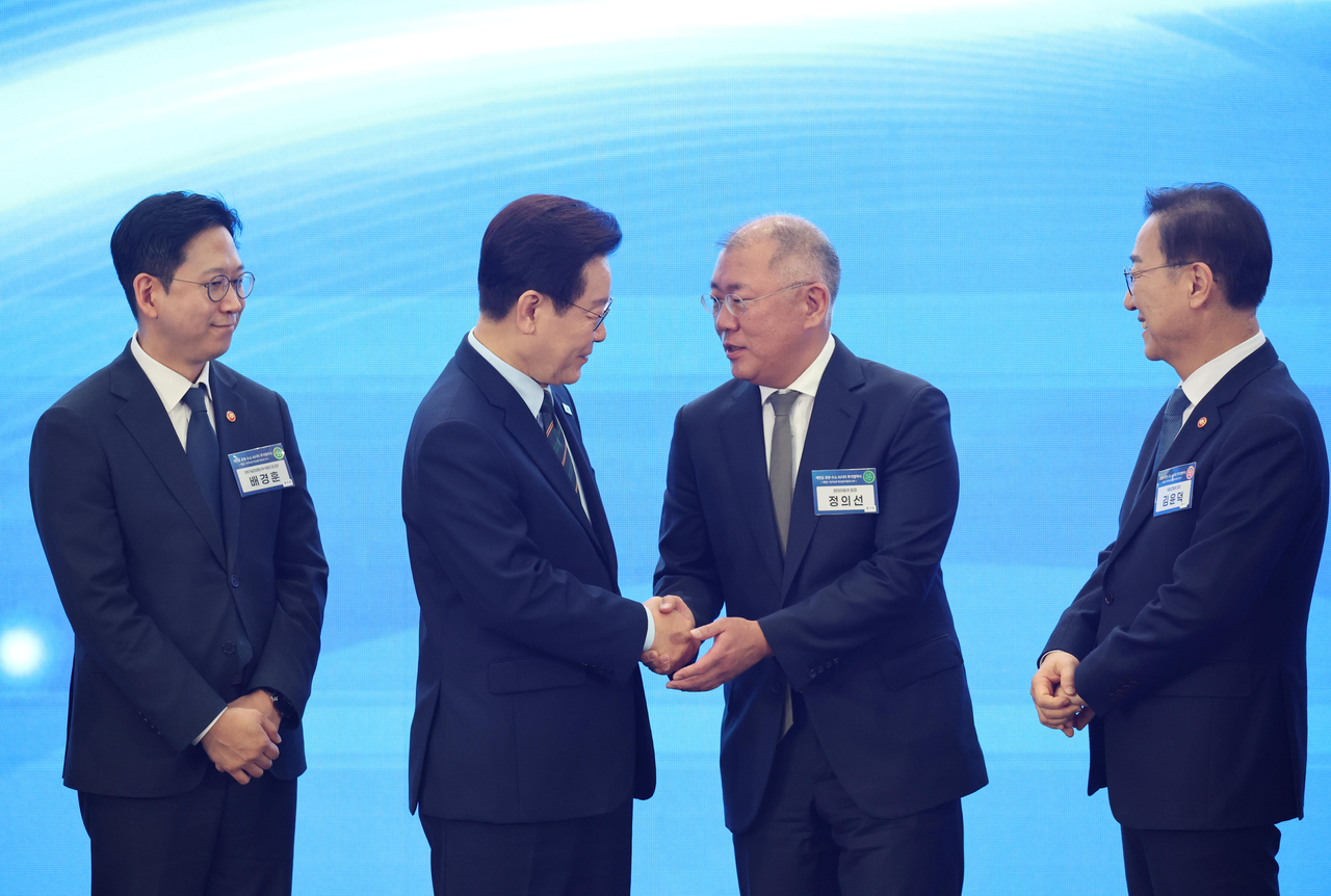 President Lee Jae Myung (second from left) shakes hands with Hyundai Motor Group Chair Euisun Chung (second from right), after attending a signing ceremony for a memorandum of understanding on supporting Hyundai Motor Group's investment in the Saemangeum reclaimed land, held at the Gunsan Saemangeum Convention Center in Gunsan, North Jeolla Province, Friday. (Yonhap)