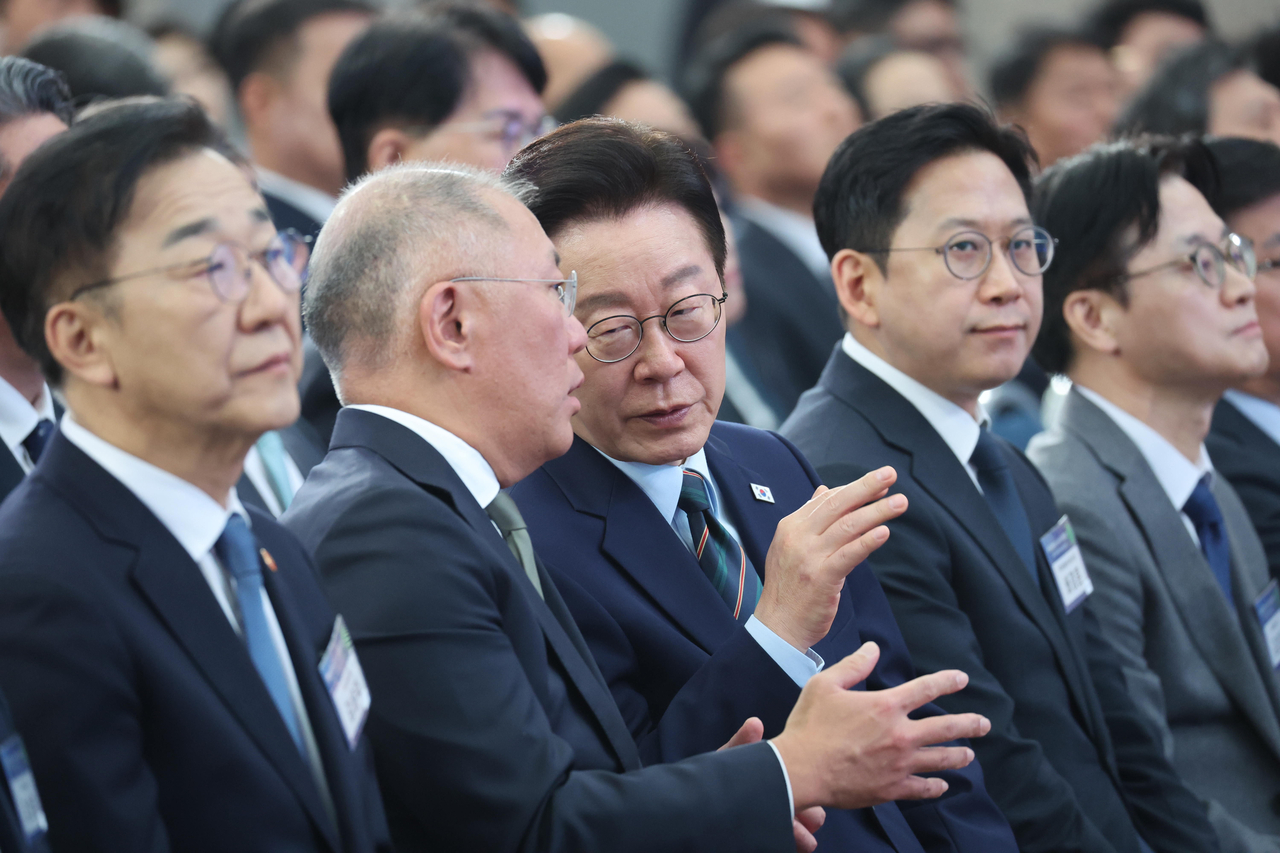 President Lee Jae Myung (center) listens to Hyundai Motor Group Chair Euisun Chung (second from left) during a memorandum of understanding signing ceremony supporting Hyundai Motor Group’s investment in the Saemangeum reclaimed land, held at the Gunsan Saemangeum Convention Center in Gunsan, North Jeolla Province, Friday. (Yonhap)