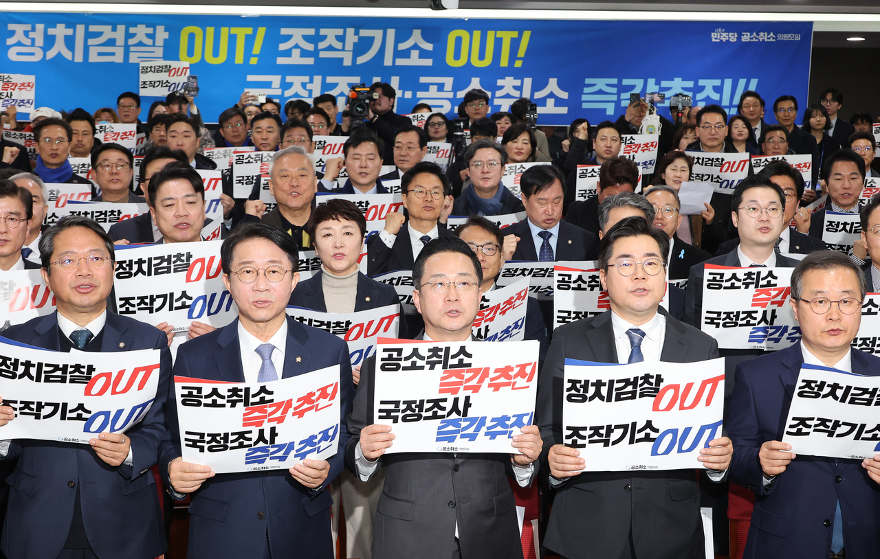 Democratic Party lawmakers hold placards as 105 lawmakers gathered to call for the cancellation of President Lee Jae Myung's criminal cases at the National Assembly in Seoul on Monday. (Yonhap)