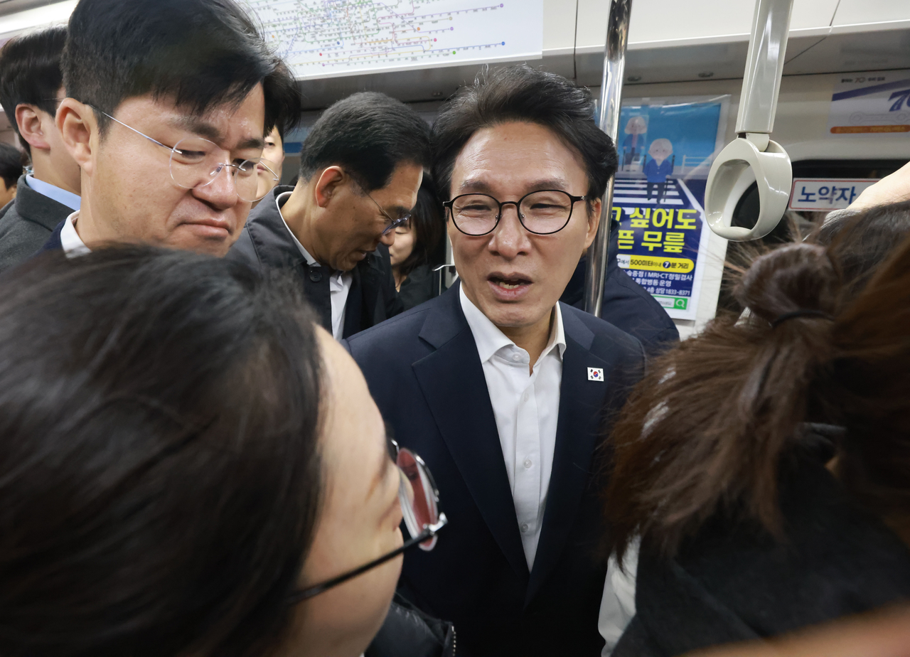Prime Minister Kim Min-seok (center) is seen aboard a train traveling along the Gimpo Goldline to inspect overcrowding in the light metro line in Gimpo, Gyeonggi Province, Friday. (Pool photo via Yonhap)