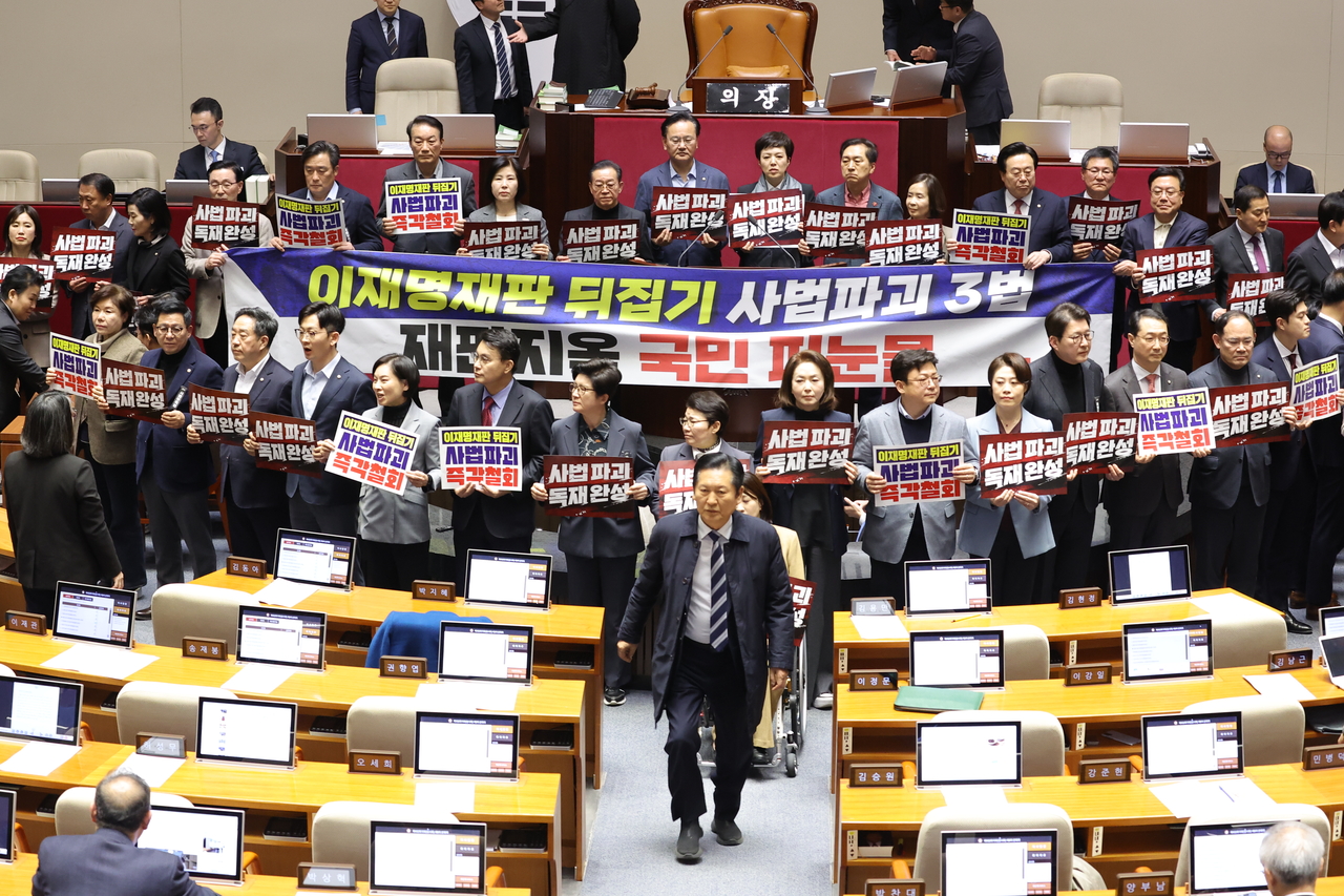 Rep. Jung Chung-rae (center, front), chair of the Democratic Party of Korea, walks along an aisle to vote to end the opposition-led filibuster on Friday. (Yonhap)