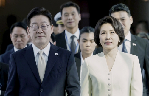 President Lee Jae Myung (L) and first lady Kim Hea Kyung arrive at Changi Airport in Singapore on Sunday. (Yonhap)