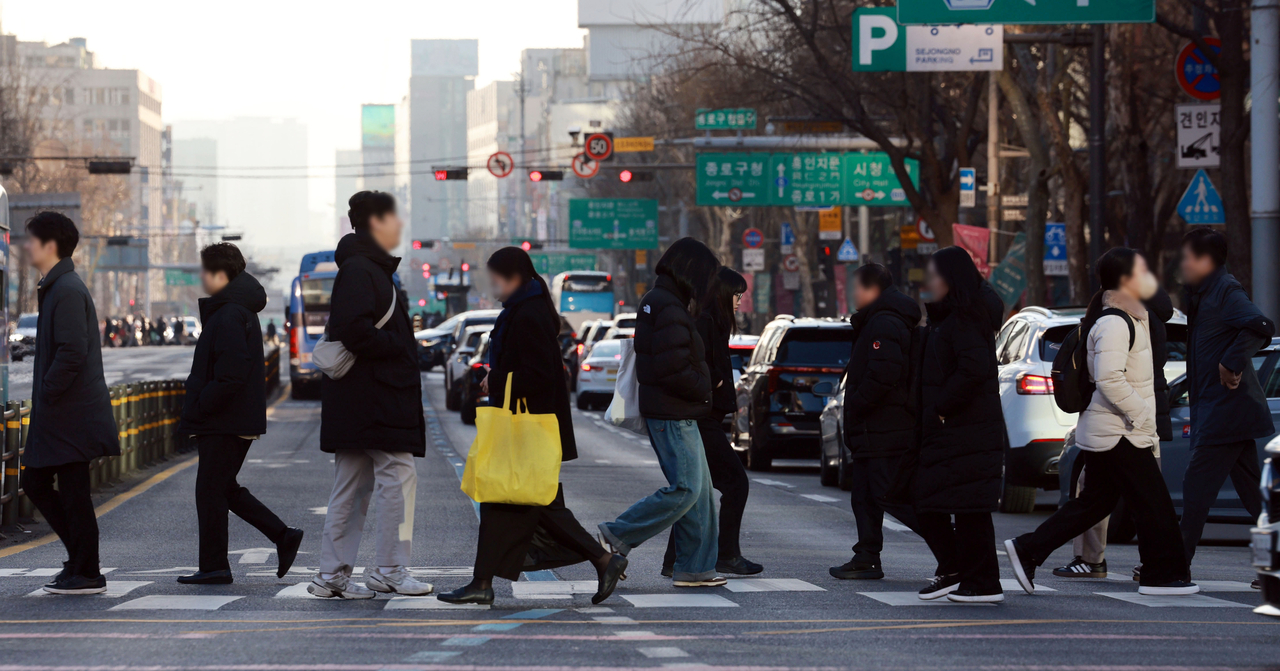 People walk through an intersection in Seoul on Feb. 19. (Yonhap)