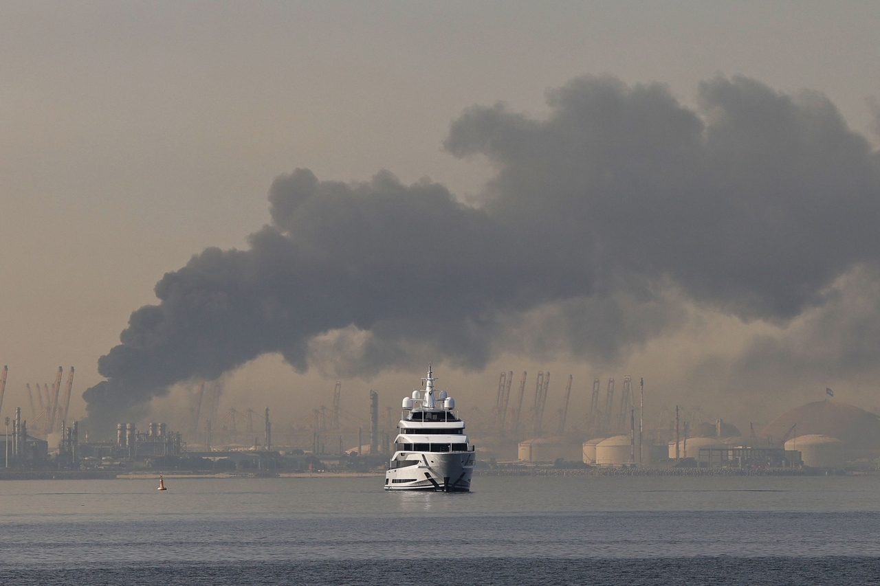 A yacht sails past a plume of smoke rising from the port of Jebel Ali following a reported Iranian strike in Dubai on Sunday. (AFP-)