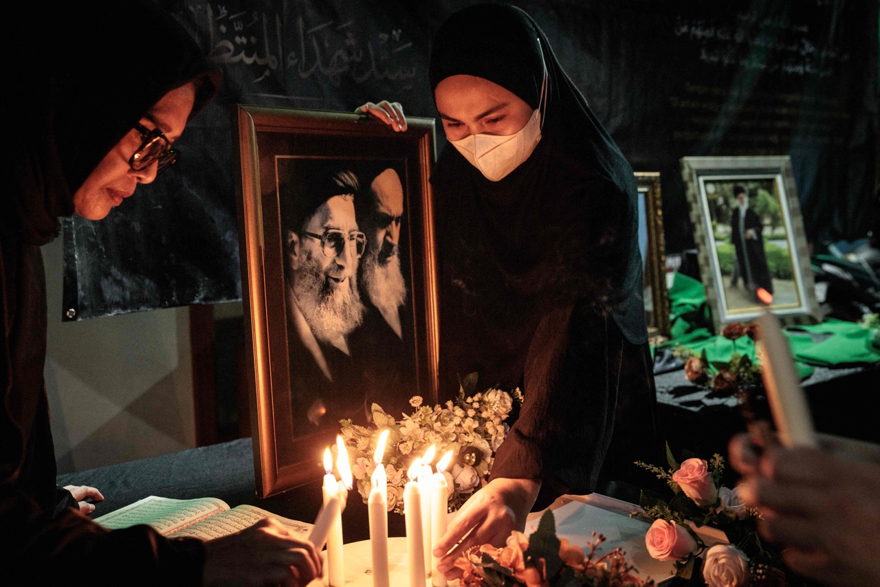 A Muslim woman holds a portrait of Iran?s Supreme Leader Ali Khamenei (L), who had led Iran since 1989 and was killed in the opening phase of a large-scale US and Israeli military operation, as a condolence area is set up at the Islamic Cultural Center Jakarta in Jakarta on March 1, 2026. (AFP)