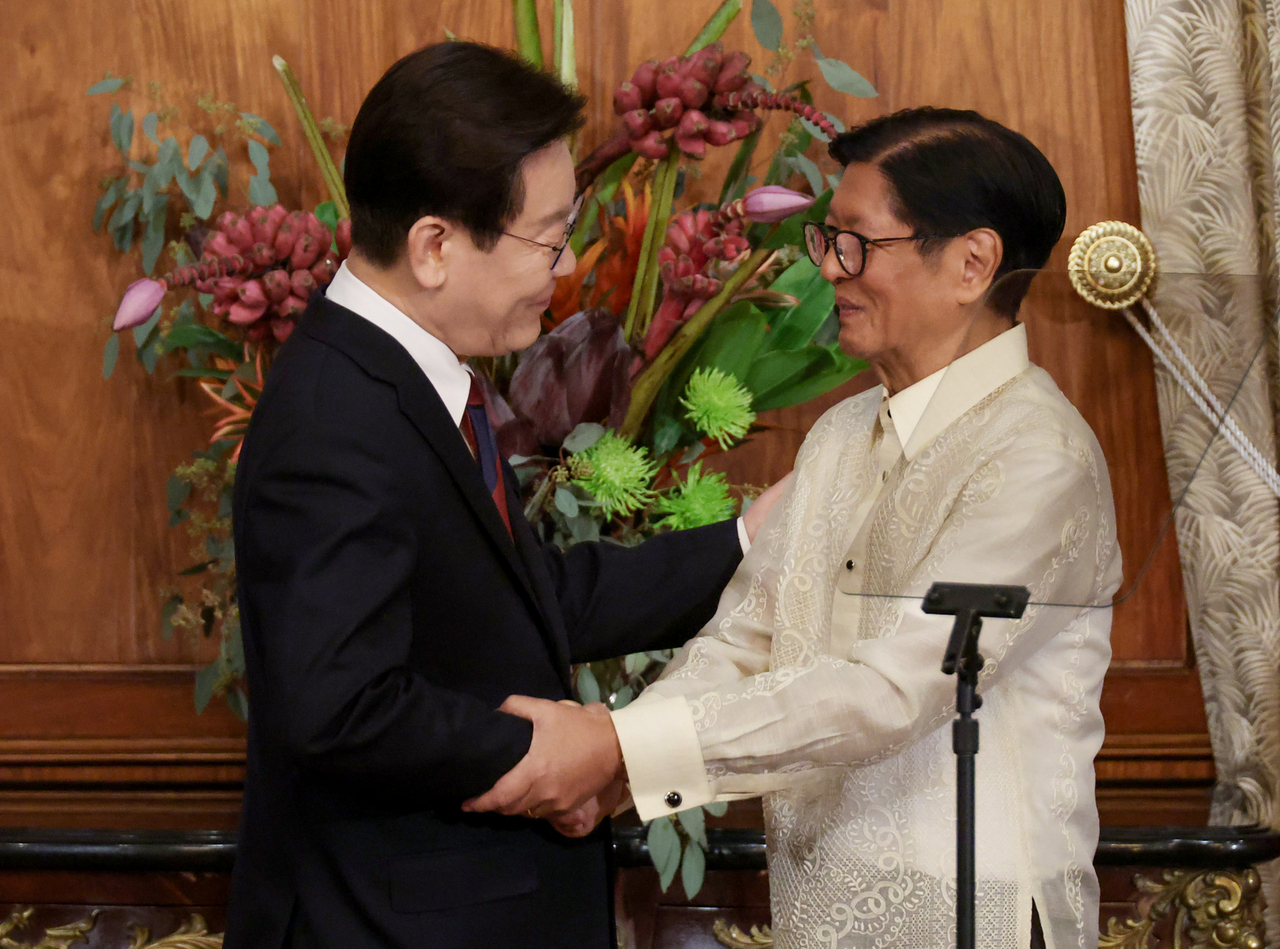 South Korean President Lee Jae Myung (left) shakes hands with Philippine President Ferdinand Marcos Jr. after their joint news conference at Malacañang Palace in Manila on Tuesday. (Yonhap)
