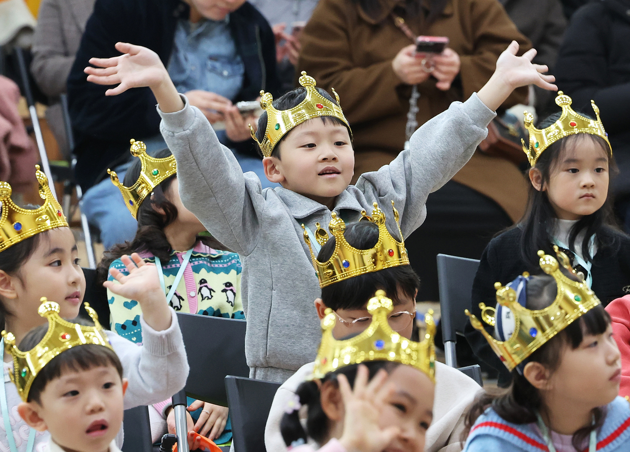 A first grader waves to his parents during the entrance ceremony at Daepyeong Elementary School in Suwon, Gyeonggi Province, Tuesday. (Yonhap)