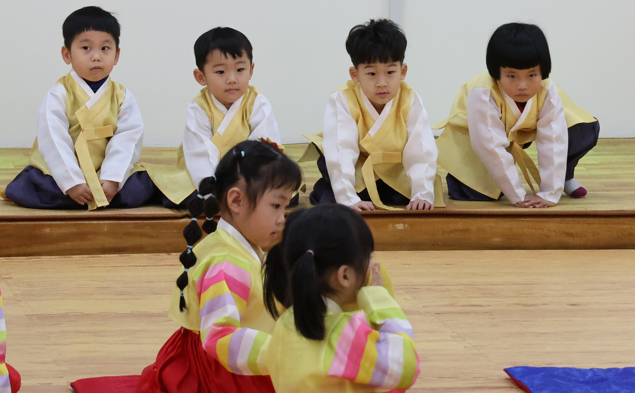 Kindergarteners wearing hanbok practice bowing on Jan. 16 ahead of Korea's Lunar New Year holiday in Busan. (Yonhap)