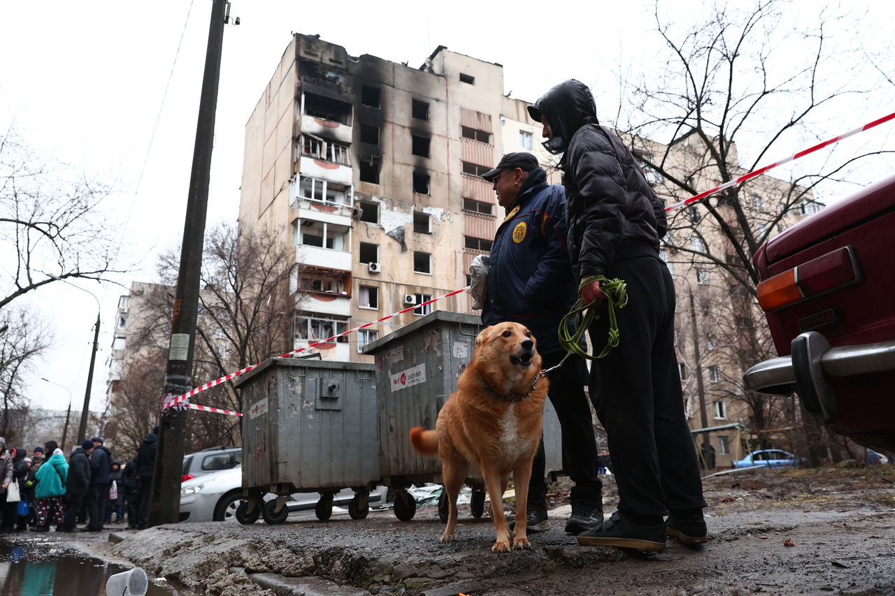 Local residents walk a dog near a damaged apartment building hit by Russian drone in Zaporizhzhia, Ukraine, in February. (AP-Yonhap)